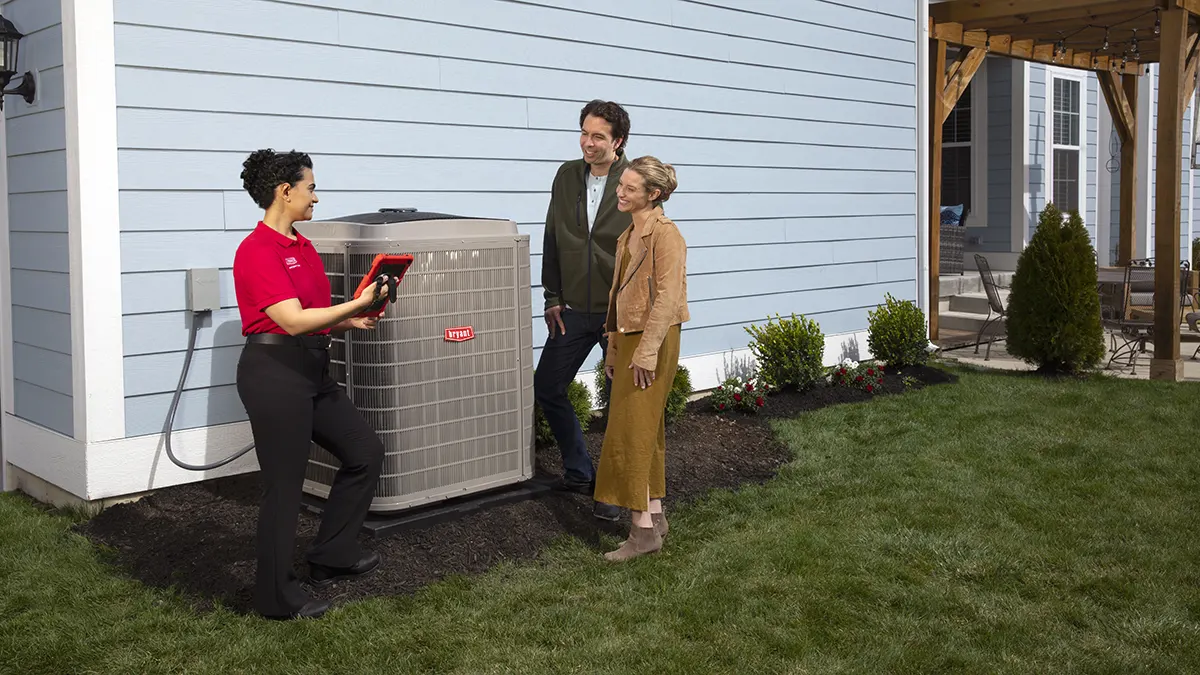 Heat Pump Installer talking with homeowners by outdoor heat pump unit | Heat Pump Install | ZAP Cooling and Heating