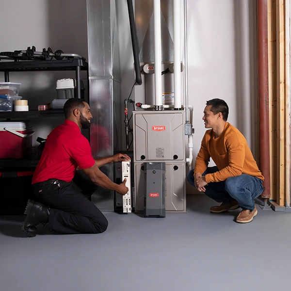 HVAC technician with customer beside basement furnace | Furnace Repair | ZAP Cooling and Heating