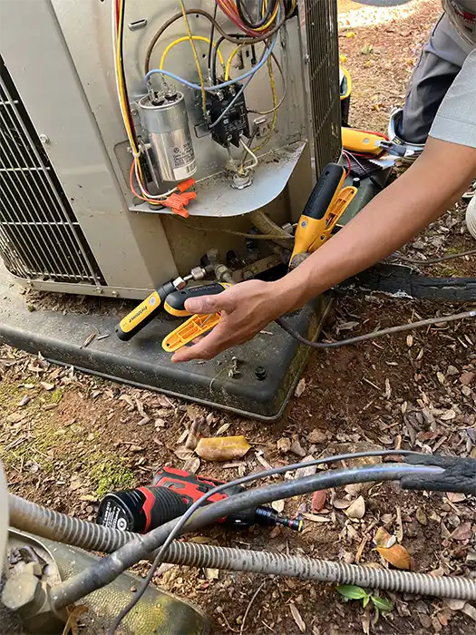 Technician repairing an outdoor AC unit | Cumming, Georgia | AC Repair | ZAP Cooling & Heating